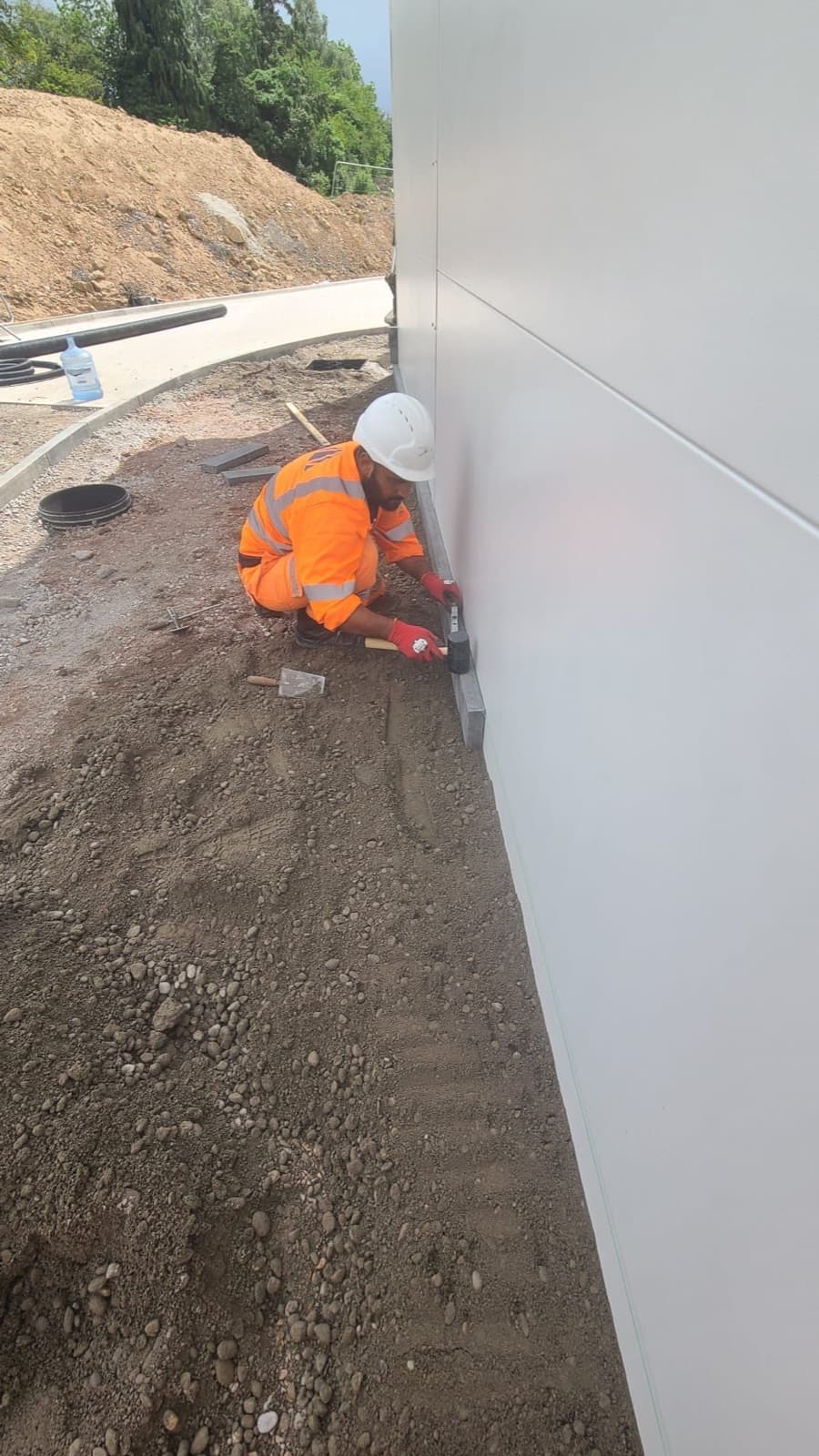 Operative installing kerbing beside a commercial building