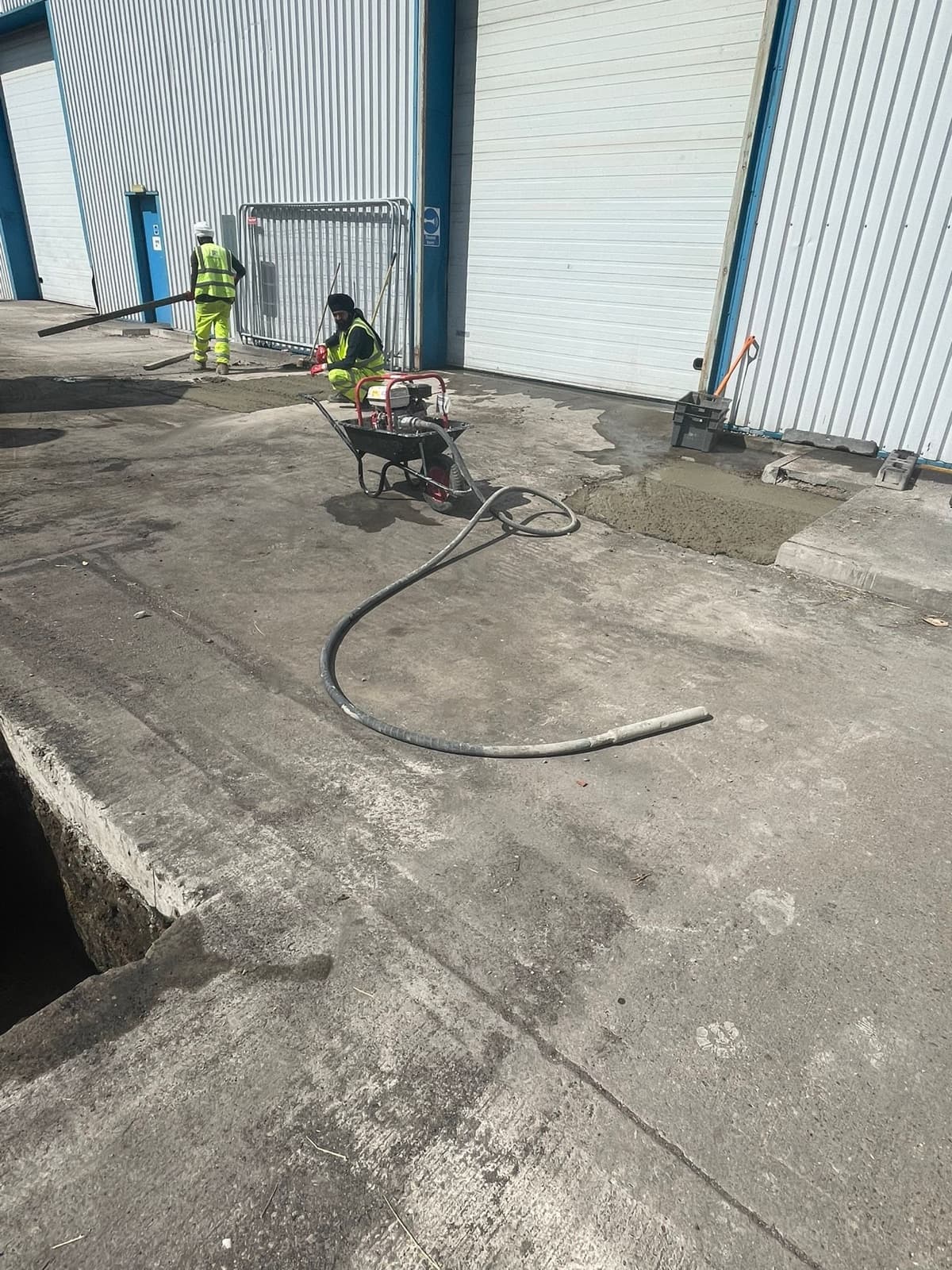 Operatives carrying out concrete repairs outside an industrial building
